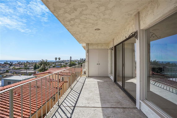 Balcony with railing overlooking a coastal view.