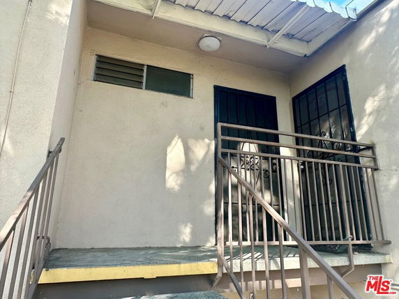Front view of a building entry with two doors and a small metal railing.