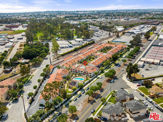 Aerial view of a residential area with multiple houses and a swimming pool in the center.