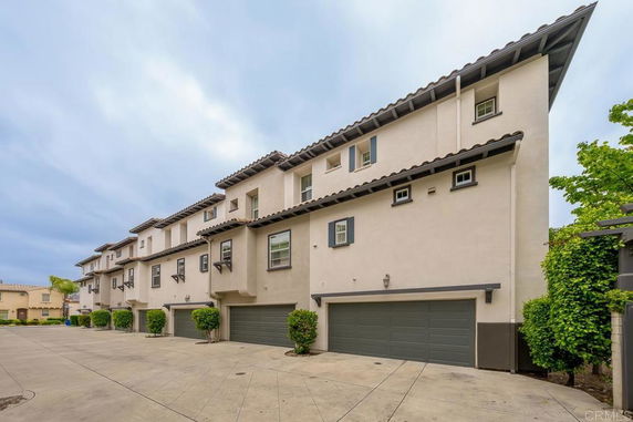 Front view of a multi-story building with garage doors.