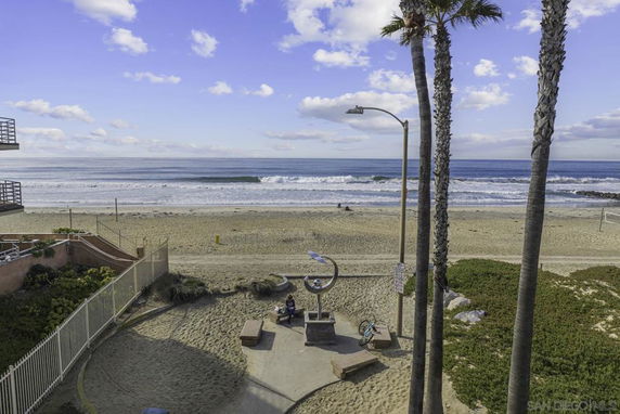 Panoramic view of a beachfront area with a sandy beach and ocean waves.