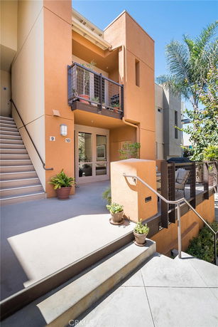 Front view of a two-story building with balconies and stairs.
