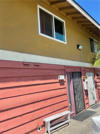 Front view of a two-story building with colorful siding and doors.
