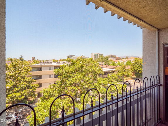 View from a building showing surrounding urban area with trees and other buildings.