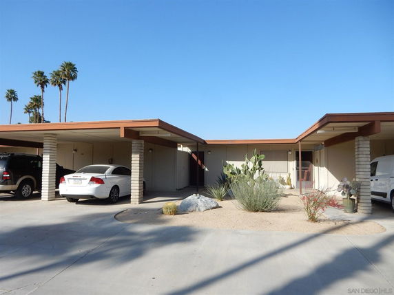 Front view of a house with carport and desert landscaping.