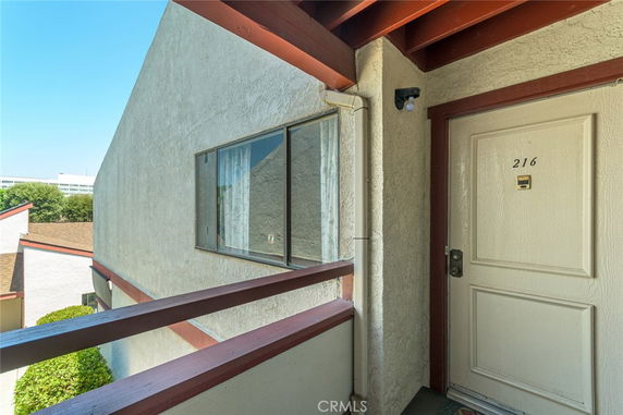 Exterior view of an apartment entrance with a window and door labeled 216.