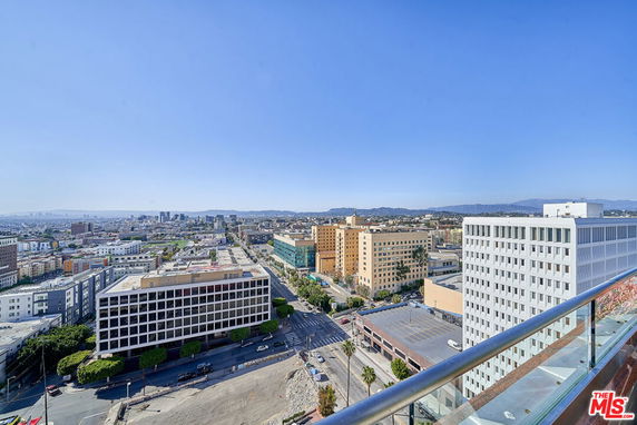 Panoramic view of a cityscape with various buildings and a clear blue sky.
