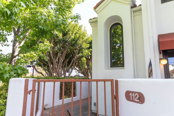 Front view of a house with a large arched window and white exterior walls.