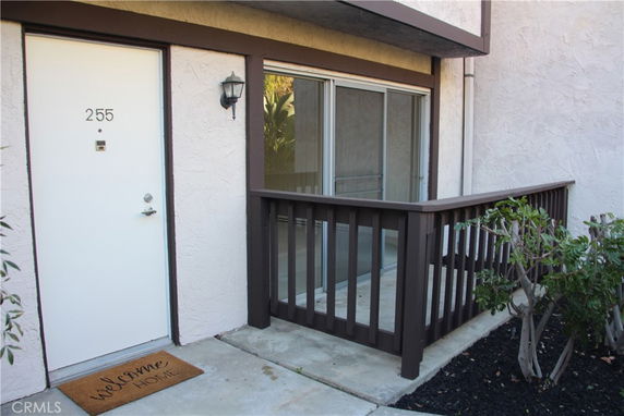 Front view of a building entrance with a door labeled 255 and a small porch area.