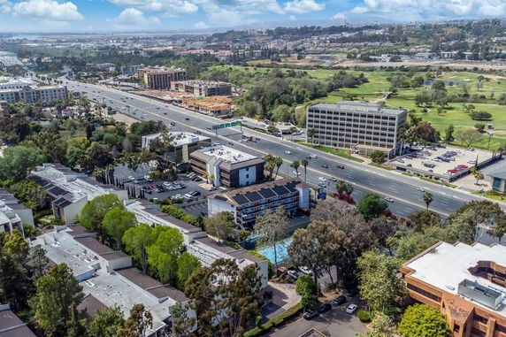 Panoramic view of a city area with roads, buildings, and greenery.