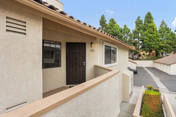 Front view of a residential building with a tiled roof and entrance pathway.