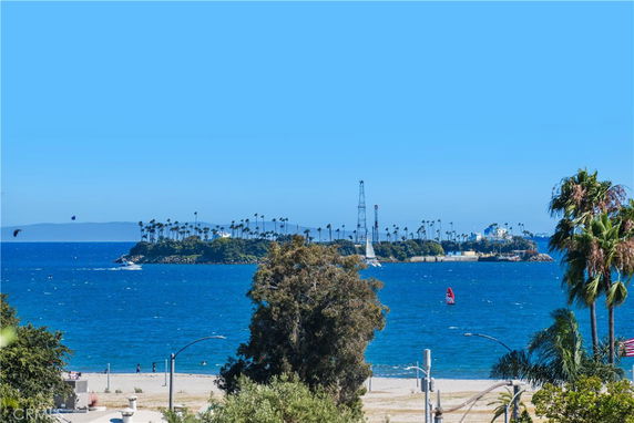 Wide angle view of a coastal area with ocean and distant island.