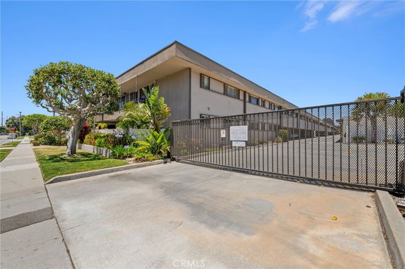 Front view of a two-story building with a gated entrance and landscaping.