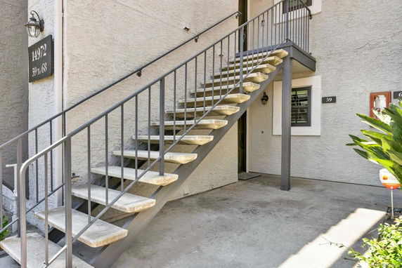 Exterior staircase leading to the entrance of a multi-unit building.