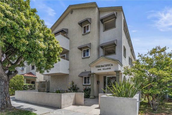 Front view of a multi-story residential building with a covered entrance.