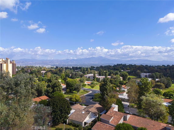 Panoramic view of a residential area with distant mountains and a clear blue sky.