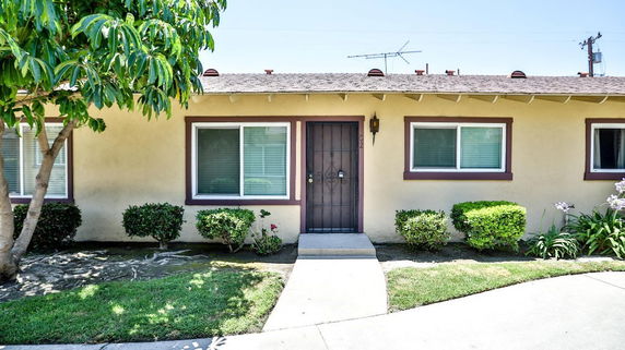 Front view of a single-story house with a door and two windows.