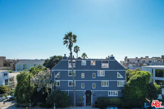 Front view of a multi-story building with blue facade and distinct angled rooflines.