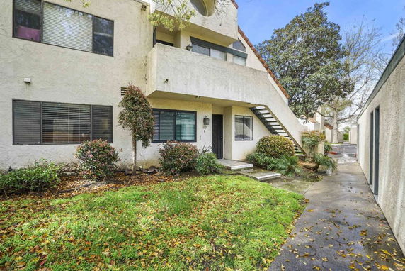 Front view of a two-story residential building with an external staircase.
