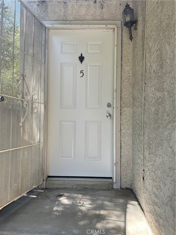 Entrance view of a house with a white door marked with the number 5.
