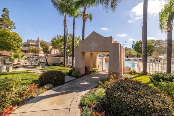 Outdoor swimming pool area with a decorative entrance and greenery.