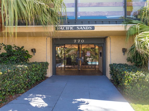 Front view of a building entrance with the sign 'Pacific Sands' above the doorway.