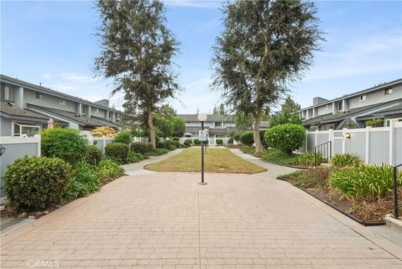 Front view of a two-story building with a walkway and landscaped garden.