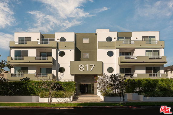 Front view of a multi-story apartment building with balconies.