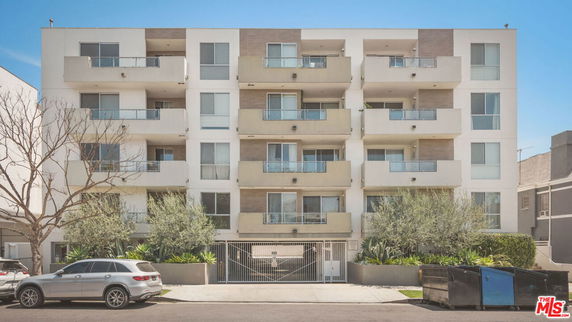 Front view of a multi-story apartment building with balconies.