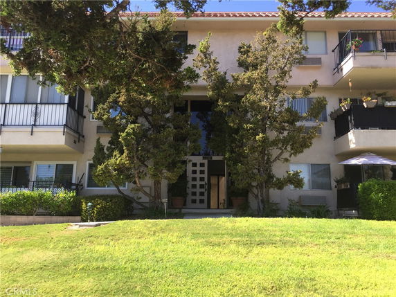 Front view of a multi-story residential building with balconies.