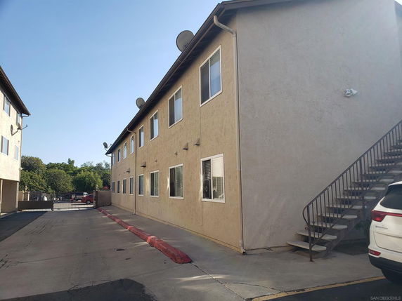 Side view of a two-story apartment building with exterior stairs.