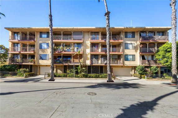 Front view of a multi-story apartment building with balconies.