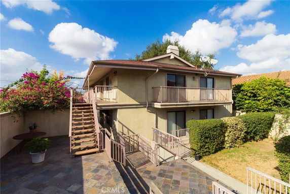 Front view of a two-story house with outdoor stairs and balconies.