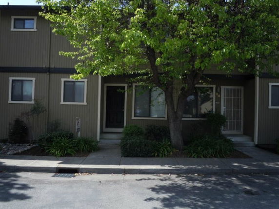 Front view of a two-story townhouse with a tree.