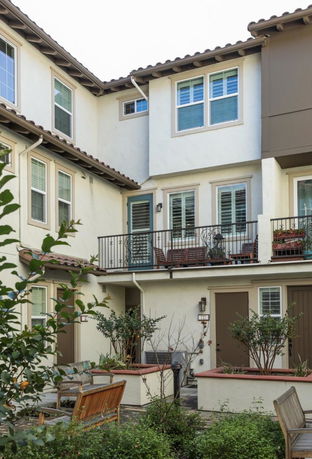 Front view of a multi-story residential building with a balcony.