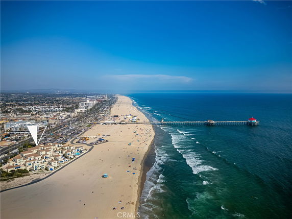 Panoramic view of a beach with a pier extending into the ocean.