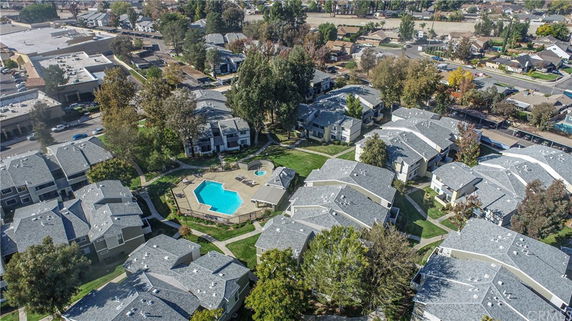 Aerial view of a residential complex with multiple buildings and a central swimming pool.