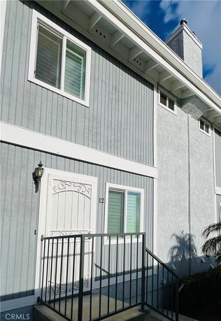 Front view of a two-story building with a white door and windows.