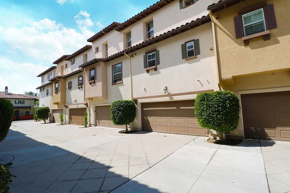 Front view of a multi-story townhouse complex with garages.