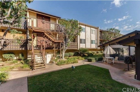 Front view of a multi-story apartment building with outdoor staircases.