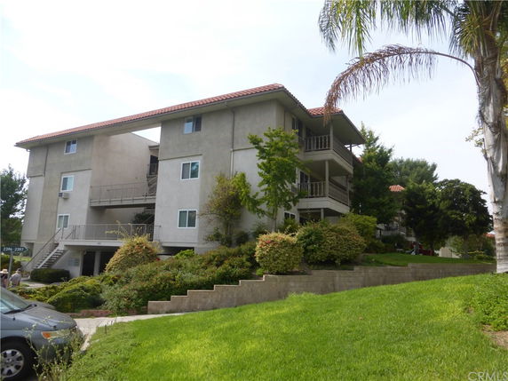 Front view of a multi-story apartment building with balconies.