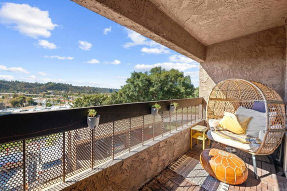 Covered balcony area with chair and décor, offering a panoramic view of the surrounding landscape.