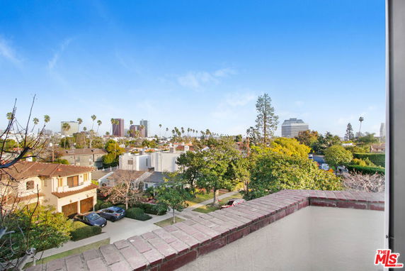 Panoramic view of a neighborhood with houses and skyscrapers in the distance.