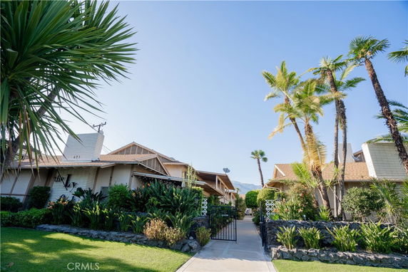 Front view of houses with a pathway and lush vegetation.