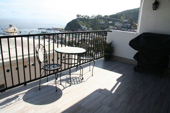 View from a balcony overlooking the ocean and a hillside town.