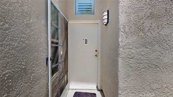 Entrance view of a building with a white door and surrounding walls.