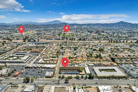 Panoramic view of a cityscape with multiple buildings and mountains in the background.