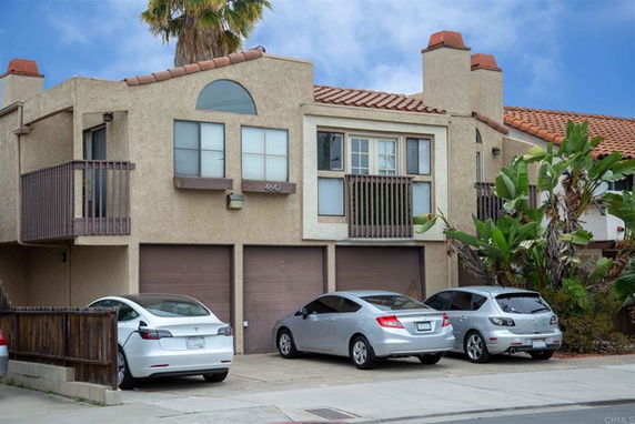 Front view of a two-story house with balconies and attached garages.