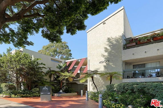 Front view of a multi-story building with balconies and large number signage.