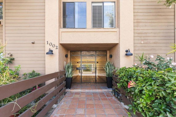 Entrance view of a house with a gated entry and decorative plants.